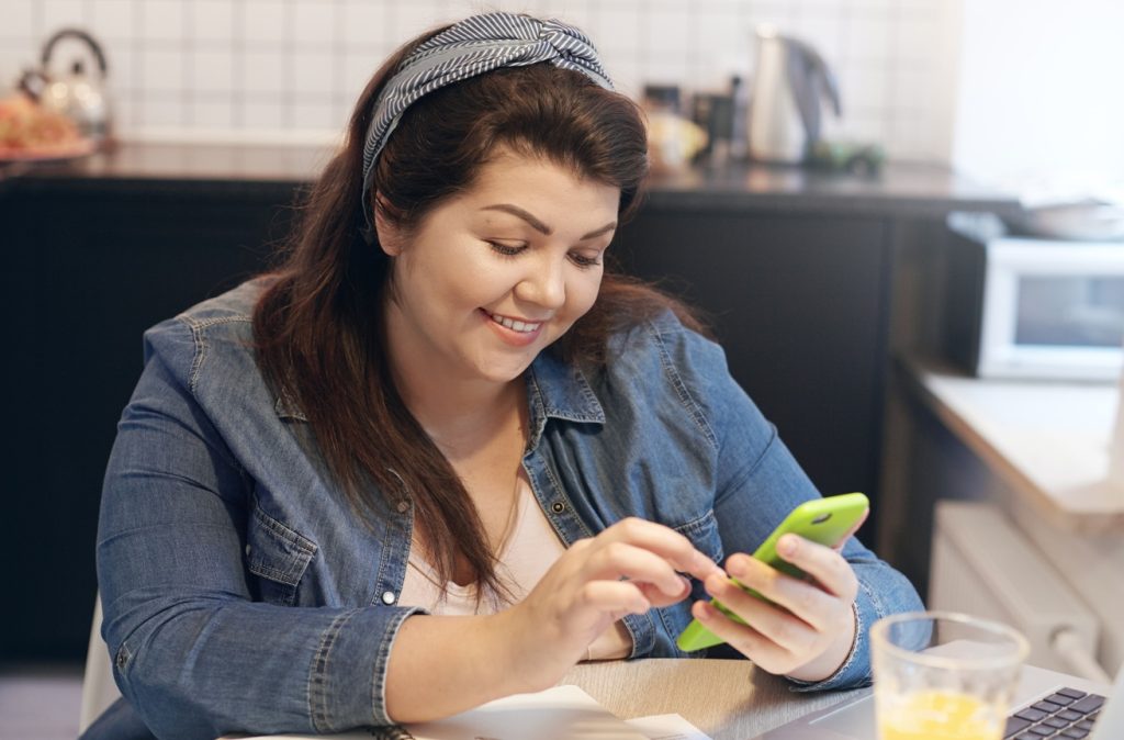 mujer revisa el interés compuesto de su cuenta desde celular