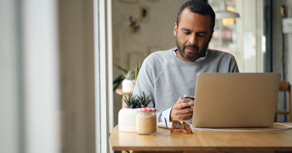 Hombre revisa en su celular la devolución de renta de quinta categoría